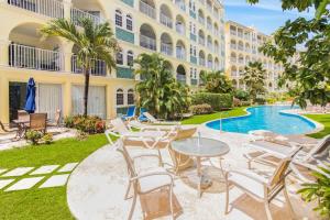 Un patio con mesas y sillas frente a un edificio. en Sapphire Beach Condos, en Christ Church 5 fotos más