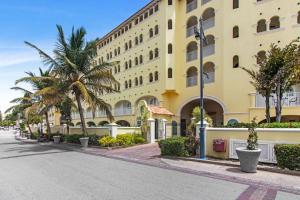 un gran edificio amarillo con palmeras delante en Sapphire Beach Condos, en Christ Church