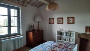 a bedroom with a bed and a dresser and a window at Antico Casale Il Borgo San Martino in Campo in San Martino in Campo