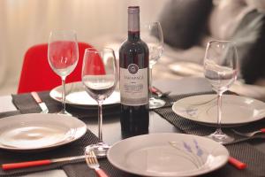 una botella de vino sentada en una mesa con copas en Mardisa Design em Cabo Branco por Carpediem, en João Pessoa