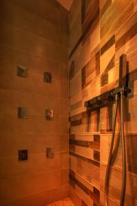 y baño con ducha y paredes de madera. en B&B Piazza Roma, en Norma