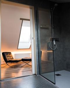a glass shower door with a chair in a room at Scenic Penthouse - Ocean view & skylight windows in Siglufjörður
