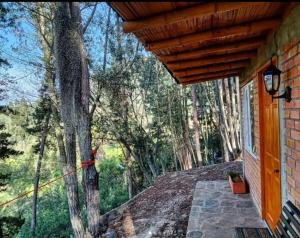 une terrasse couverte d'une maison avec un arbre dans l'établissement Quinta de Fagua, à Sutatausa
