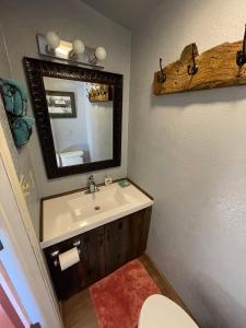 y baño con lavabo, espejo y aseo. en Lava Hideout Cabins, en Lava Hot Springs