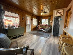 Lava Hideout Cabins في لافا هوت سبرينغس: غرفة معيشة بجدران خشبية وأرضية خشبية
