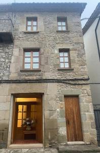 un edificio de piedra con 3 ventanas y 2 puertas en Cala Pepita en Alpens