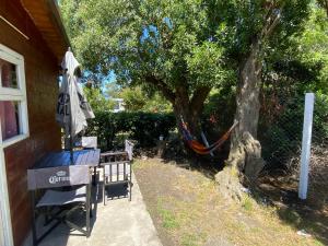a patio with an umbrella and a hammock next to a tree at Evergreen in Mar del Plata +1 photo