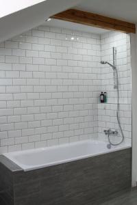 a white bath tub with a shower in a bathroom at Ferienwohnung Stefanko in Bernau