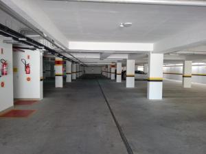 un garaje vacío con columnas blancas y techos blancos en Duplex lindo sofisticado, en Governador Celso Ramos