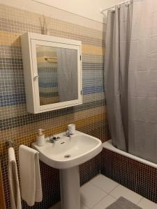 a bathroom with a sink and a mirror and a shower at Lovely and Cozy Quiaios 1 Bed Apartment in Palheiros de Quiaios