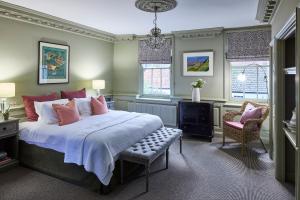 sypialnia z łóżkiem, krzesłem i oknami w obiekcie The Mistley Thorn w mieście Mistley