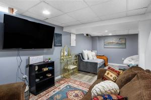 uma sala de estar com uma televisão de ecrã plano na parede em Boho cozy home, quiet, free parking (private room unless specified) em Kalamazoo
