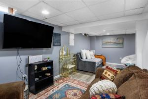 ein Wohnzimmer mit einem Flachbildfernseher an der Wand in der Unterkunft Boho cozy home, quiet, free parking (private room unless specified) in Kalamazoo