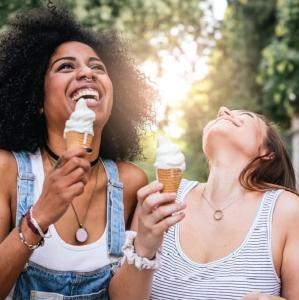dos mujeres riendo mientras comen conos de helado en Romarina, en Roma