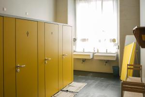 uma casa de banho com armários amarelos, um lavatório e uma janela em casaBASE em Milão