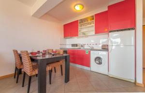 cocina con armarios rojos, mesa negra y sillas en B42 - Ocean Apartment, en Portimão
