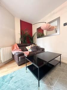 a living room with a leather couch and a table at El Olivar de Las Rozas in Las Rozas de Madrid
