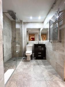La salle de bains est pourvue de toilettes et d'une douche en verre. dans l'établissement El Olivar de Las Rozas, à Las Rozas de Madrid