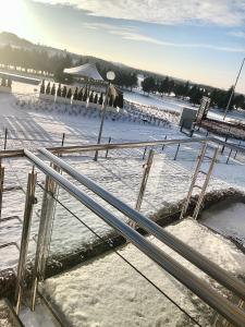 a snow covered parking lot with a metal railing at Golf Apartament 10 in Wejherowo