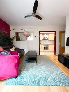 a living room with a pink couch and a table at El Olivar de Las Rozas in Las Rozas de Madrid