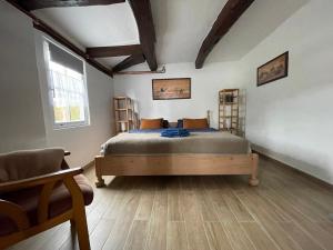 een slaapkamer met een bed in een kamer met houten vloeren bij Hexenhüsli Waake 