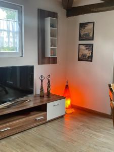 a living room with a flat screen tv and orange walls at Hexenhüsli Waake 