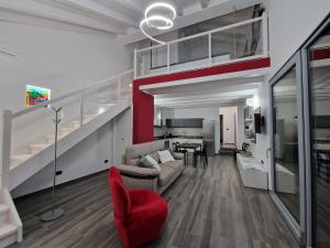 ein Wohnzimmer mit einem Sofa und einem roten Stuhl in der Unterkunft Bellagio Il Crotto in Bellagio