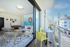 a balcony with chairs and a table and a couch at Good times by HolyGuest in Tel Aviv