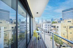 a balcony with a table and chairs and a view of the city at Good times by HolyGuest in Tel Aviv