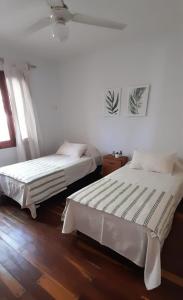 une chambre avec deux lits et une fenêtre dans l'établissement Departamento céntrico en San Martín, amplio, con aire acondicionado y cochera privada, à San Martín