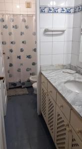 une salle de bain avec un lavabo, des toilettes et une douche dans l'établissement Departamento céntrico en San Martín, amplio, con aire acondicionado y cochera privada, à San Martín