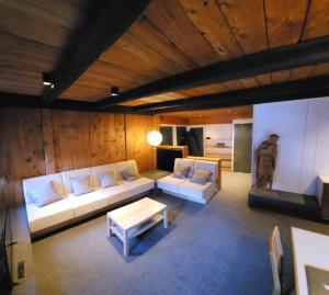 ein Wohnzimmer mit einem Sofa und einem Tisch in der Unterkunft ATI Appartamento stile Chalet dell 800 nel cuore di Ortisei in St. Ulrich in Gröden