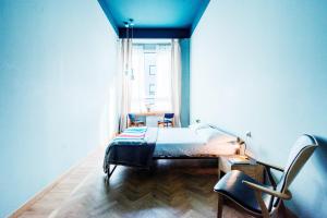 a bedroom with a bed and a window and a chair at casaBASE in Milan +10 photos