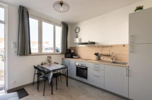 a kitchen with a table and a dining room at La Maisonnette Du Parc in Le Creusot