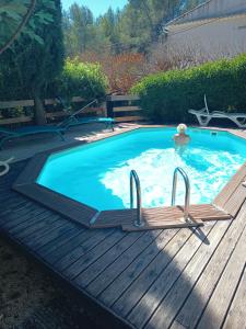 een zwembad met een houten terras en een zwembadvisor bij VILLA AVEC PISCINE A 400M DE LA PLAGE in Sanary-sur-Mer