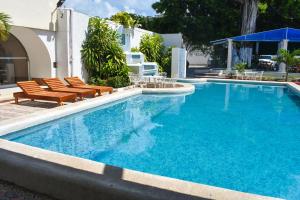 una gran piscina con 2 sillas en Hotel Maria de Lourdes, en Cancún