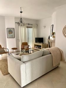 een witte woonkamer met een bank en een tafel bij Appartement Casa Lina Lagos vue mer in Lagos