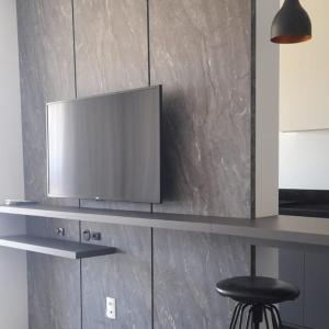 a flat screen tv on a counter in a kitchen at Apartamento Central em Canela in Canela
