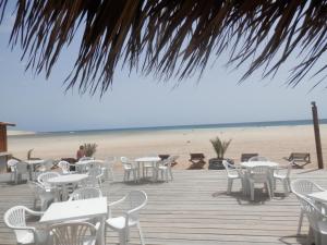 a wooden deck with tables and chairs on the beach at BCV - Private 2 Bed Penthouse Apartment with Pool View Dunas Resort 4044 in Santa Maria