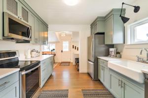 eine Küche mit grünen Schränken und einem Waschbecken in der Unterkunft Cozy Farmhouse-Style Cottage by Mighty 5 Ntl Parks in Circleville