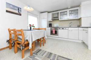 kuchnia z białymi szafkami oraz stołem i krzesłami w obiekcie Ferienwohnung Hafeneck w mieście Neuharlingersiel