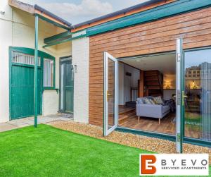 a house with sliding glass doors and a yard at ByEvo Oswestry Barn - Quirky romantic retreat or cosy contractor base in Oswestry