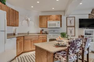 a kitchen with wooden cabinets and a table with chairs at Laurelwood Condominiums 304 in Snowmass Village