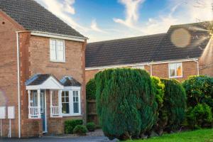 a brick house with bushes in front of it at Taylor Close in Fishtoft