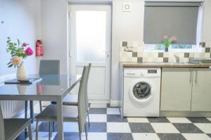 a kitchen with a table and a washing machine at Taylor Close in Fishtoft