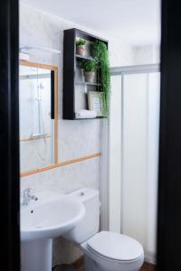 La salle de bains est pourvue de toilettes blanches et d'un lavabo. dans l'établissement Hotel Ventus, à El Médano
