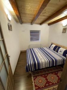 ein kleines Schlafzimmer mit einem Bett und einem Fenster in der Unterkunft Cabana Tudor in Avrig