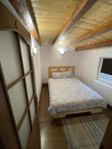 ein kleines Schlafzimmer mit einem Bett und einem Fenster in der Unterkunft Cabana Tudor in Avrig