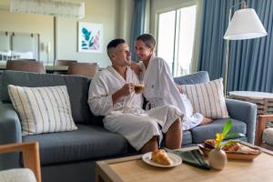 a man and woman sitting on a couch drinking wine at Omni Orlando Resort at Championsgate in Kissimmee