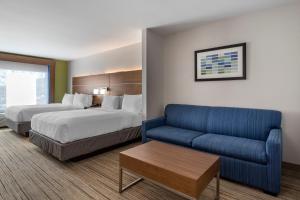 een hotelkamer met 2 bedden en een bank bij Holiday Inn Express Hotel and Suites Natchitoches, an IHG Hotel in Shamard Heights